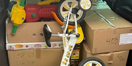 Powiększ grafikę: Bagażnik samochodu wypełniony kartonami, zabawkami i darami do transportu