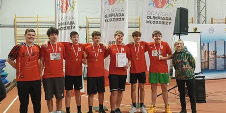 Powiększ grafikę: „Zespół uczniów z medalami i pucharem pozuje do zdjęcia podczas Gdańskiej Olimpiady Młodzieży.”