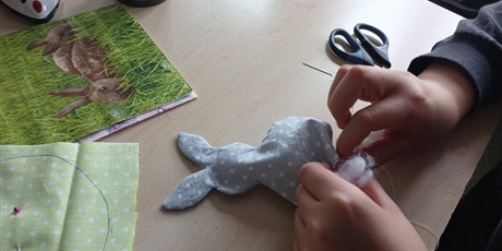 Powiększ grafikę: Uczeń wypełnia watą materiałowego zajączka wielkanocnego podczas pracy ręcznej