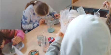 Powiększ grafikę: Kilkoro uczniów pracuje przy stoliku z klejem i materiałami.