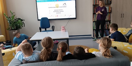 Powiększ grafikę: „Grupa uczniów uczestniczy w zajęciach wychowawczych, oglądając prezentację na ekranie w klasie.”